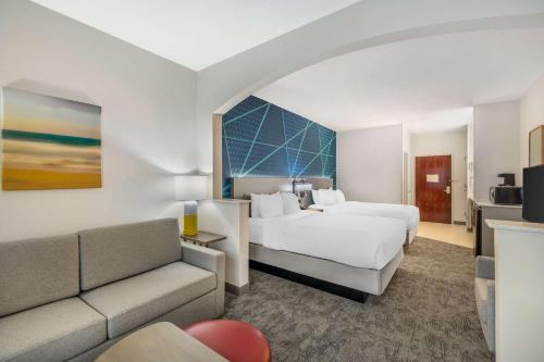 a hotel room with two beds and a couch at Comfort Suites Redmond Airport in Redmond