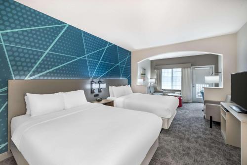 a hotel room with two beds and a desk at Comfort Suites Redmond Airport in Redmond