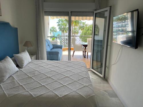 ein Schlafzimmer mit Bett und Fernseher und Balkon in der Unterkunft Mi Capricho, Luxury Apartment in Mijas Costa