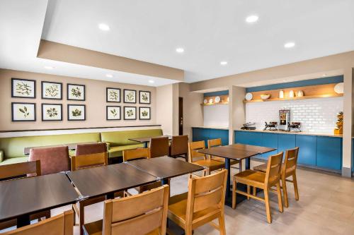 a restaurant with tables and chairs and a kitchen at Country Inn & Suites by Radisson, LSU - Medical Corridor in Baton Rouge