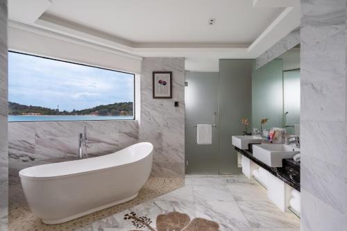 a bathroom with a white tub and a sink at Lexis Hibiscus Port Dickson in Port Dickson