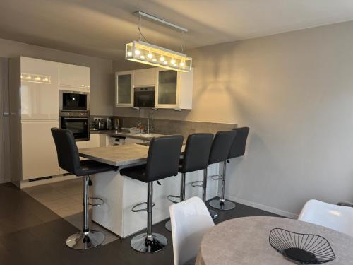 - une cuisine avec un bar avec des chaises et une table dans l'établissement Appartement PLACE MORNY, HYPER CENTRE !, à Deauville