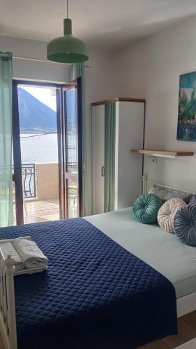 a bedroom with a blue bed with a view of the ocean at Joković Accommodation in Kotor