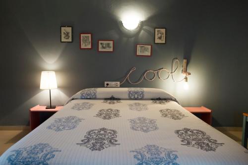 a bedroom with a bed with aigil sign on the wall at Complejo Rural La Belluga in Segorbe