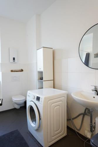 a washing machine in a bathroom with a sink at 3BR - City Apartments - Kitchen - 10 min to ICE in Siegburg