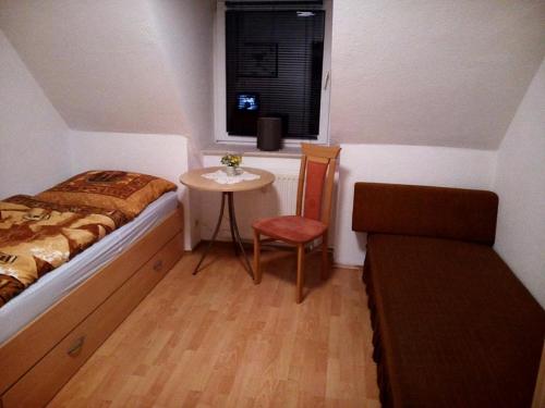 ein Schlafzimmer mit einem Bett, einem Tisch und einem Stuhl in der Unterkunft Gästewohnung Hennig in Böhlen
