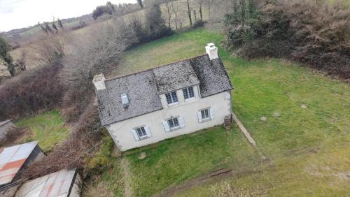 une vue aérienne d'une maison dans un champ dans l'établissement Three Bedroom Breton Cottage, à Collorec