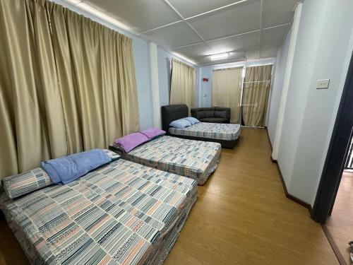 a hotel room with two beds and a couch at Tang's Crib in Miri