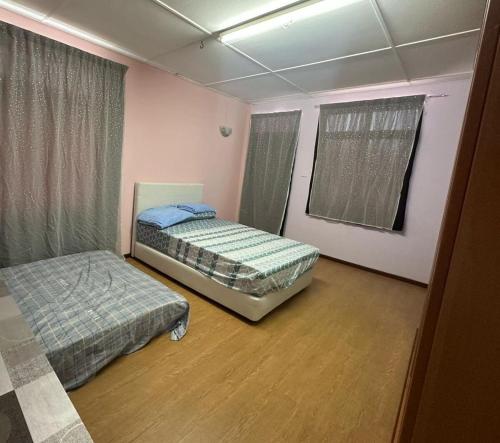 a bedroom with two beds in a room at Tang's Crib in Miri
