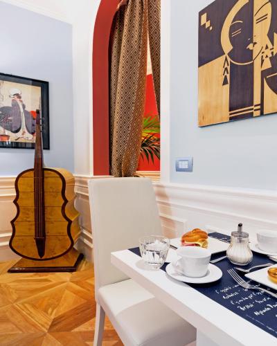 een eetkamer met een tafel en een gitaar bij La Maison du Sage in Florence