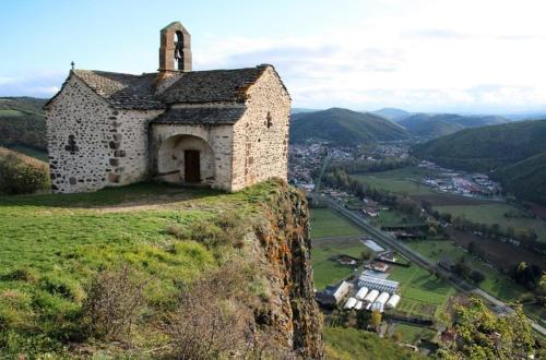 un vieux bâtiment sur le côté d'une colline dans l'établissement Maison Cantalou, à Massiac