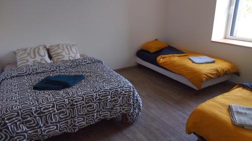 Cette chambre comprend un lit, un lit et un canapé. dans l'établissement Gite de saint Antoine, à Ploudiry