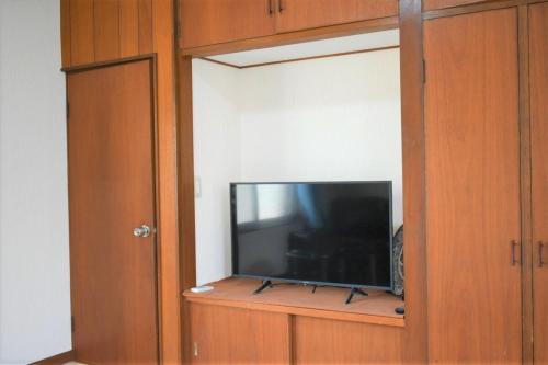 a flat screen tv in a wooden entertainment center at Near the sea House 2nd two-story detached house in Hannan
