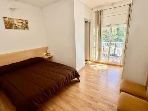 Un dormitorio con una cama y una ventana grande. en Vela el Vent 1, en Sant Carles de la Ràpita