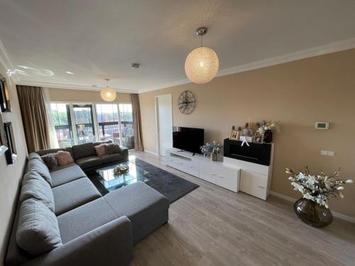 a living room with a couch and a tv at Beautiful luxury Apartment with Skyline in Rotterdam