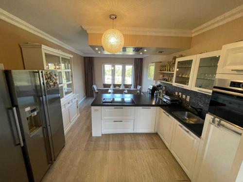 a kitchen with white cabinets and a black counter top at Beautiful luxury Apartment with Skyline in Rotterdam