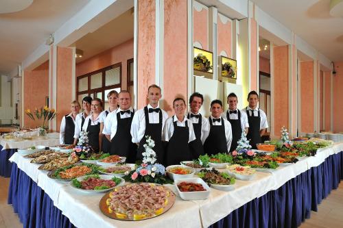 a group of people standing around a table with food at Hotel Adria in Milano Marittima