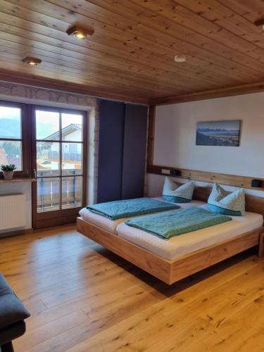 Un dormitorio con una cama con techo de madera. en Landhaus Poppler mit Aufzug, en Hopferau