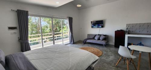 a bedroom with a bed and a large window at White Villa in Koh Rong