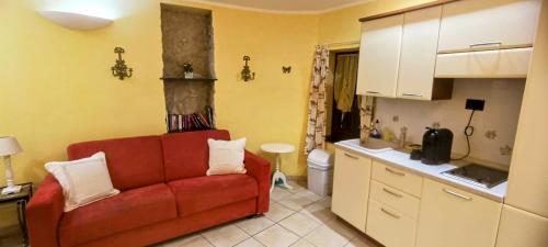 un salon avec un canapé rouge dans une cuisine dans l'établissement Studio Vieux Village Roquebrune Cap Martin RCM, à Roquebrune-Cap-Martin