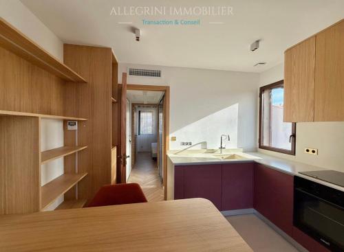 une cuisine avec des armoires en bois et un comptoir dans l'établissement Appartement citadelle, vue mer, à Calvi