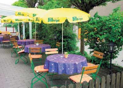 a group of tables and chairs with purple tables and umbrellas at Hotel-Gasthof Lamm in Rot am See