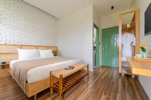 a bedroom with a bed and a green door at Manling Retreat Hoi An in Hoi An
