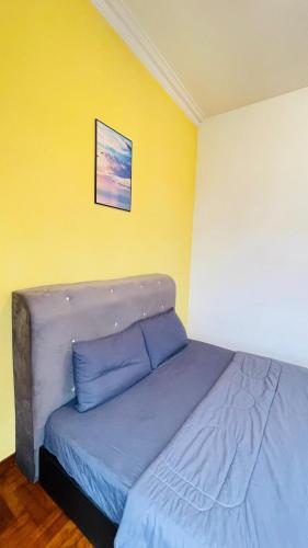 a bed in a room with a yellow wall at Rinting Masai Semi-D Snooker Ping Pong 6R 20 Paxs in Masai