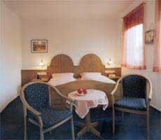 Rot am SeeにあるHotel-Gasthof Lammのテーブルと椅子2脚が備わるホテルルームです。