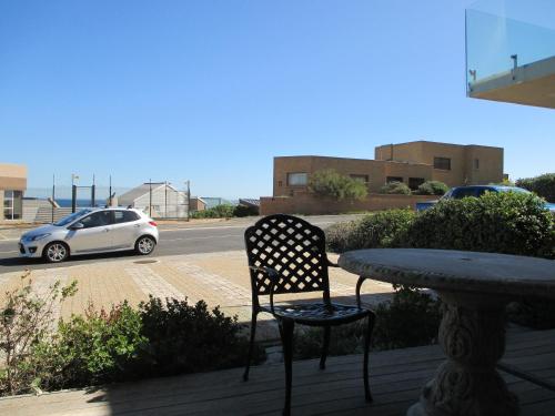 a chair sitting next to a table and a car at Mt Bijoux Preferred Accommodation in Bloubergstrand