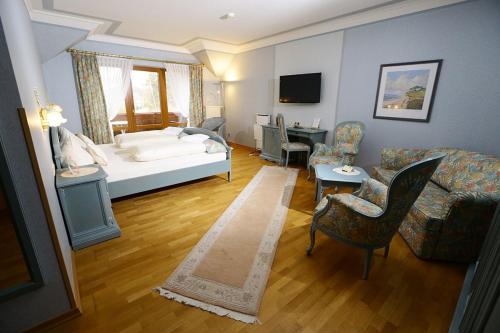 a bedroom with a bed and a living room with a couch at Landhaus Sonnenhof in Adenau