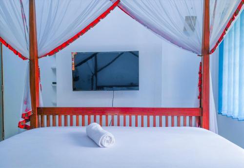 a bed with a canopy with a white pillow on it at Maasai Koroga Hotel & Apartments in Mombasa