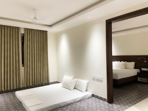 a hotel room with a bed and a mirror at SV Grand in Mettuppālaiyam