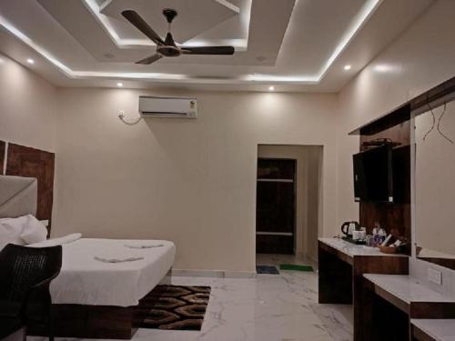 a room with a bed and a ceiling fan at The Sea Horse in Mandarmoni
