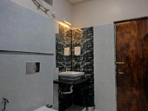 a bathroom with a sink and a wooden door at The Sea Horse in Mandarmoni