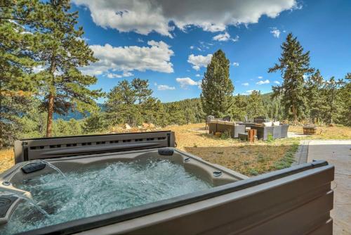a tub with water in it with trees in the background at Colorado Lux Private Cabin Hot Tub Game Room A in Woodland Park