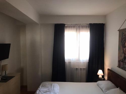 a bedroom with a bed and a window at First Choice Apartment in Skopje