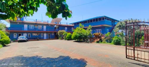 a blue building with a gate in front of it at View Point Stay in Madikeri