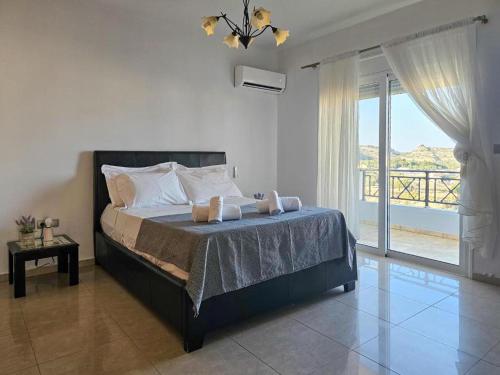 a bedroom with a bed with a view of a balcony at Calm and Joy Summer House in Afantou