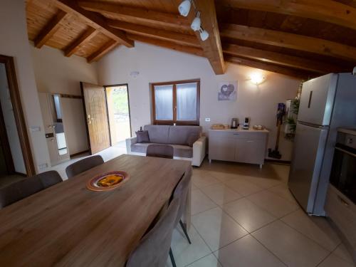 a kitchen and living room with a wooden table at La Mansarda sul lago in Bellano