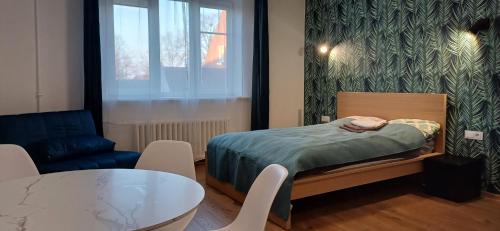 une petite pièce avec un lit et une table dans l'établissement Center & homely Apartment, à Klaipėda
