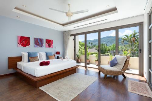 une chambre avec un grand lit et un balcon dans l'établissement The Residence Bangtao Villa 216, à Ban Thalat Choeng Thale