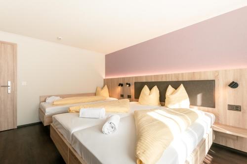 two beds in a hotel room with white walls at Hotel Kreuz in Leissigen