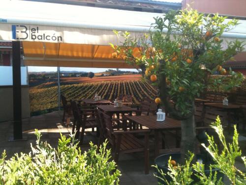 an outdoor restaurant with tables and an orange tree at Hotel El Balcón in Avilés