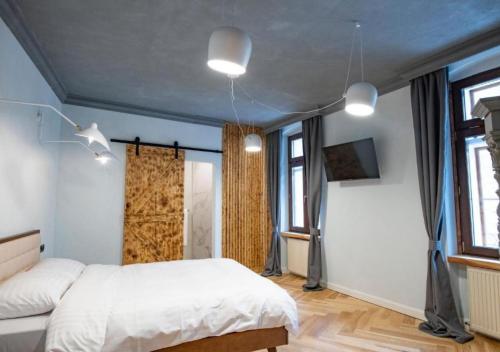 a bedroom with a white bed and two windows at Barrique Garden in Braşov