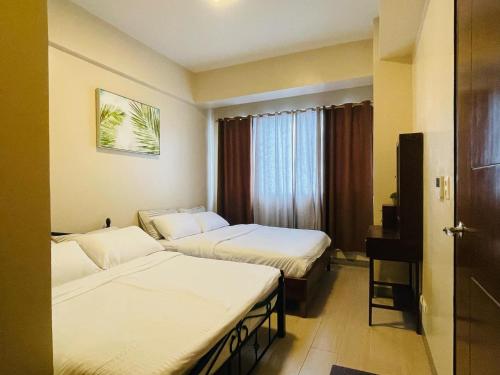 Ένα ή περισσότερα κρεβάτια σε δωμάτιο στο Cebu Mactan Newtown Family Condo