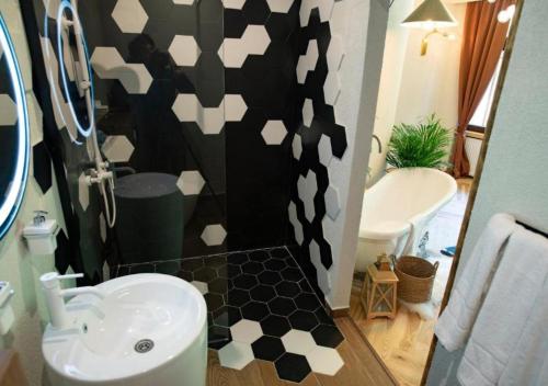 a bathroom with a black and white patterned wall at Barrique Garden in Braşov