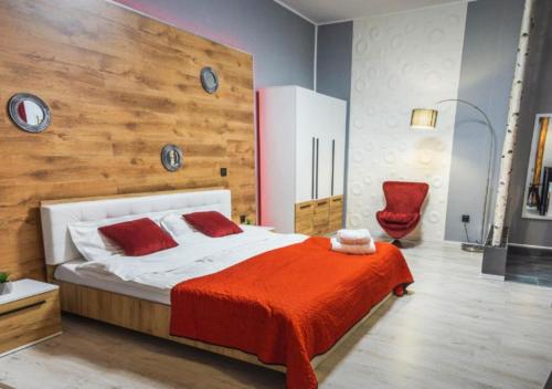 a bedroom with a large bed with a red blanket at Barrique Garden in Braşov