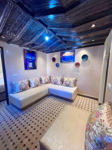 a living room with a couch and blue ceilings at Gite ECOPARADIS in Madagh
