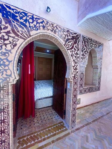 a room with an arch with a bed in it at Gite ECOPARADIS in Madagh